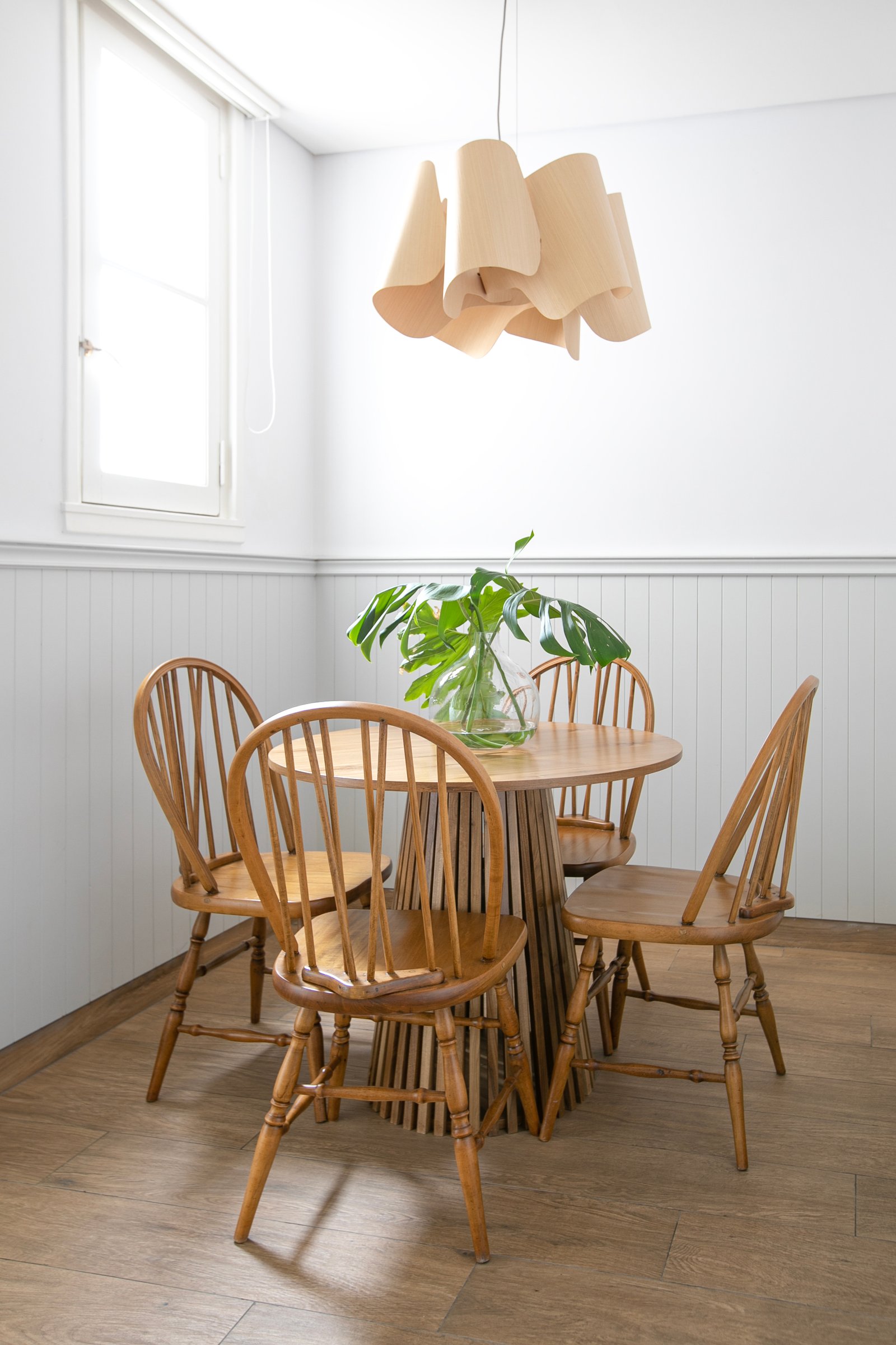Comedor escandinavo con mesa redonda y sillas Windsor — proyecto Lacroze, por Estudio Losa, en Belgrano